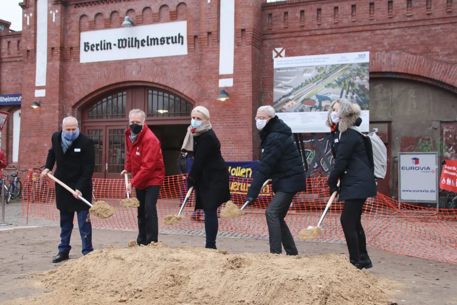 Der symbolische Spatenstich wurde am Freitag auf dem Vorplatz des S-Bahnhofs Wilhelmsruh durch Detlef Bröcker, Vorstand der Niederbarnimer Eisenbahn (NEB), Alexander Kaczmarek, Konzernbevollmächtigter der Deutschen Bahn, Regine Günther, Senatorin für Umwelt, Verkehr und Klimaschutz des Landes Berlin, Guido Beermann, Minister für Infrastruktur und Landesplanung des Landes Brandenburg und Susanne Henckel, Geschäftsführerin des Verkehrsverbundes Berlin-Brandenburg (VBB), vorgenommen (v.l.n.r.).