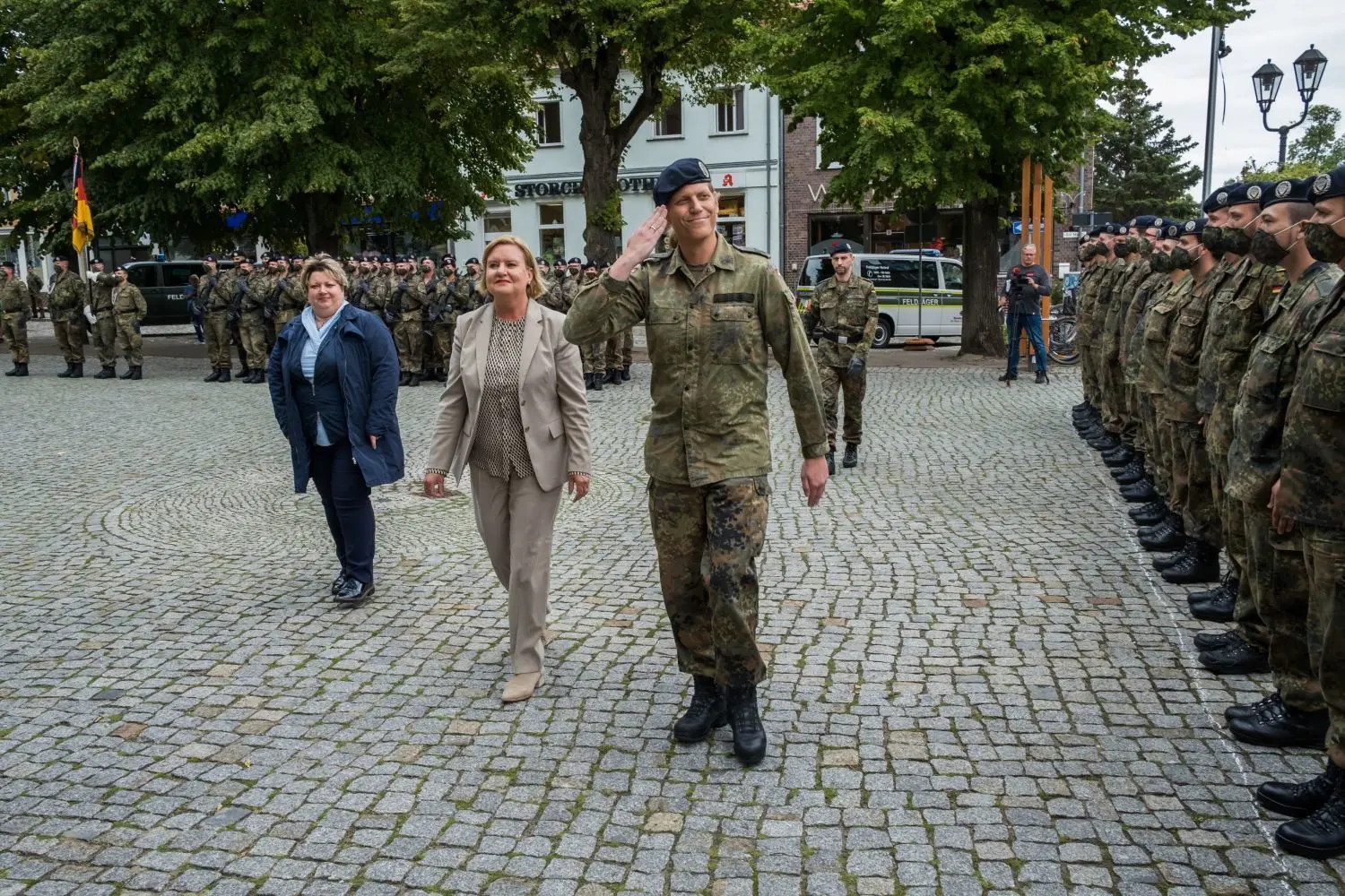 Mit Abstand: Kommandeurin Anastasia Biefang, die Wehrbeauftragte der Bundesregierung, Eva Högl, und Bürgermeisterin Cornelia Schulze-Ludwig (von vorn) schreiten auf dem Markt in Storkow die Formation der Soldaten ab.