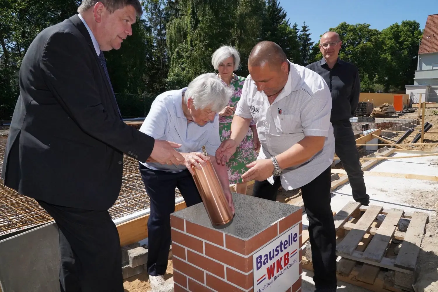 Infos für die Nachwelt: Christa Stiller, Ehrenbürgerin Werneuchens, und Bürgermeister Frank Kulicke versenken gemeinsam eine Zeitkapsel im Fundament der Senioren-Wohnanlage in Werneuchen. Gebaut wird diese von der Hoffnungstaler Stiftung Lobetal, vertreten durch Geschäftsführer Martin Wulff (l.) und die Theologische Geschäftsführerin Andrea Wagner-Pinggerá. Architekt Alexander Fountis war ebenfalls anwesend.