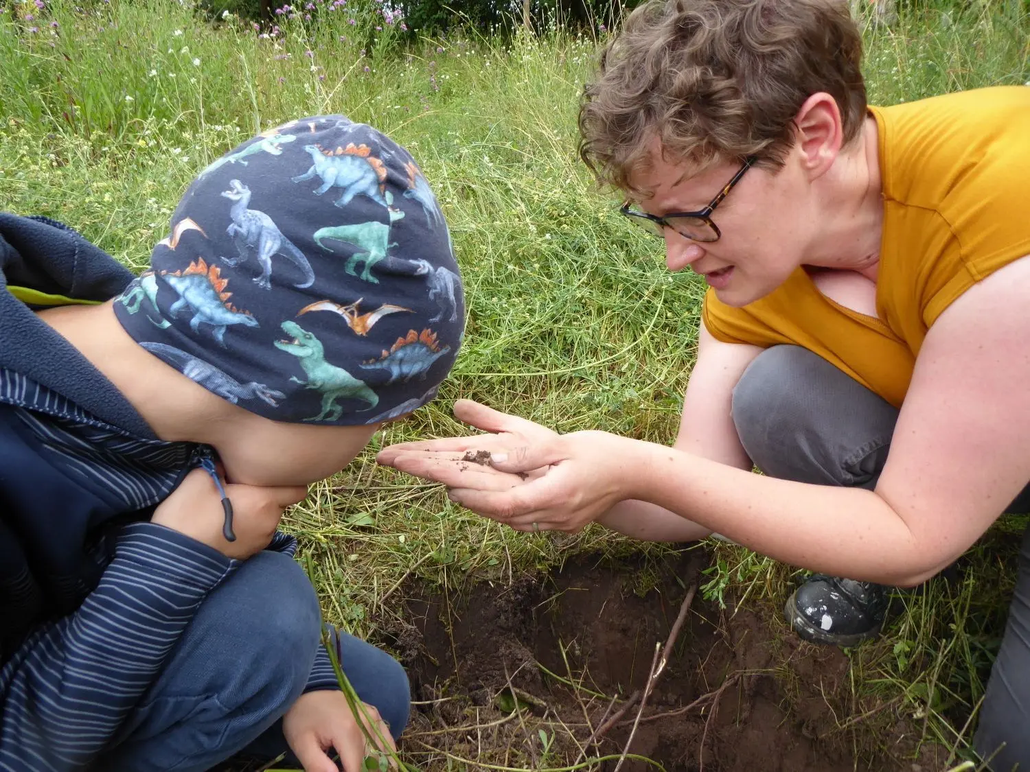 Katja Dräger und Paul entdecken Tierchen in der Erde.