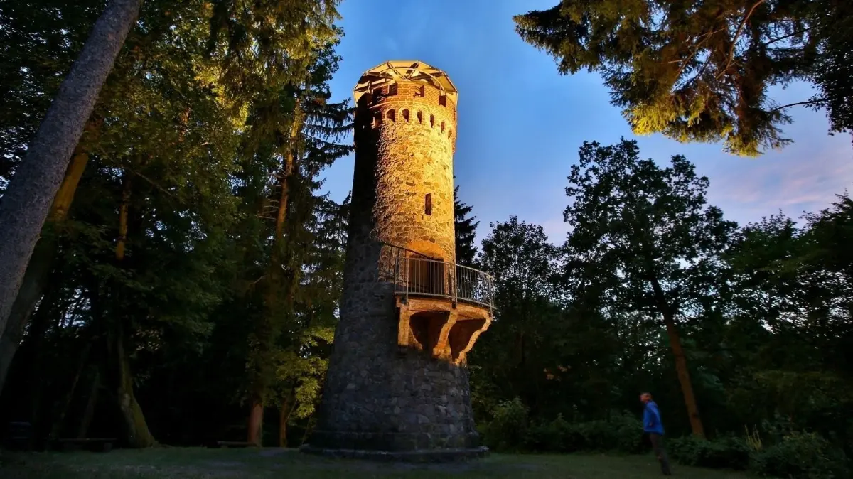 Erinnert an die einstigen Markgrafen von Brandenburg: Der Askanierturm bei Eichhorst bietet eine gute Aussicht über den Werbellinsee (Archivbild).
12.07.2016 : Der 1879 erbaute Askanierturm ist das wohl bekannteste Wahrzeichen von Eichhorst. Zwei Strahler beleuchten Turm nach Einbruch der Dunkelheit bis eine Stunde nach Mitternacht. Die Gemeinde hat in die Beleuchtung 4.300 Euro investiert. Angestrahlt wird der Turm fortan von April bis September sowie an Weihnachten und Silvester.
Der Askanierturm wurde im Jahr 1879 aus rohbehauenen Granitsteinen erbaut. Er steht an einer Stelle,an der die Markgrafen von Brandenburg aus dem Hause der Askanier im 13. und 14. Jahrhundert Hof gehalten haben. Die Bauweise des Turmes erinnert an alte Ritterburgen aus dieser Zeit. Erbaut wurde der romantische Turm von Paul Oskar Büscher. Der Baumeister war auch an der Errichtung
der Forstakademie Eberswalde und der Regulierung des Finowkanals beteiligt.
Der zwölf Meter hohe Askanierturm hat einen Durchmesser von vier Metern. Im Inneren führt eine Wendeltreppe erst bis zum Balkon, der sich auf der Seeseite befindet, und schließlich bis zur Aussichtsplattform. Zu den berühmtesten Besuchern des Turmes zählte Preußens König Friedrich
Wilhelm I., der sich 1879 in ein Gästebuch eingetragen hatte.
Auch für die Neuverfilmung des Märchens „Rapunzel“ im Jahr 2009 war der Askanierturm Kulisse.
BesucherInnen, die den Turm heute besteigen wollen, können sich den Schlüssel dafür im Eichhorster Café „Kunst & Rad“, im „Café Wildau“ oder der Touristinformation in Eichhorst holen. Die
Touristinformation ist in den Sommermonaten Montag bis Sontag von 10:00 bis 12:30 Uhr und 13:00 bis
18:00 Uhr geöffnet.
Foto:MOZ/Thomas Burckhardt
Foto:MOZ/Thomas Burckhardt