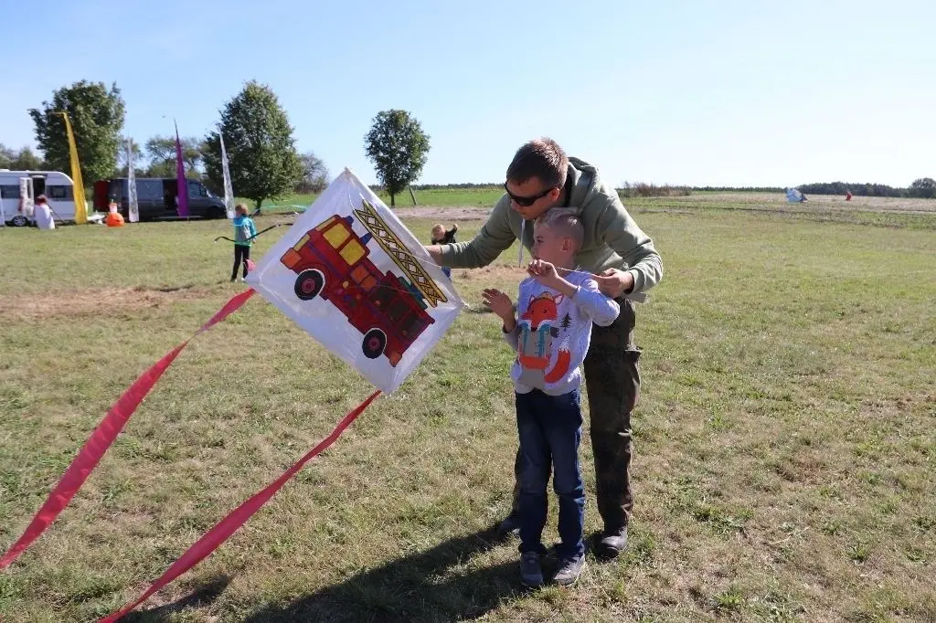 Ein Drachen mit Feuerwehrauto-Motiv: Der achtjährige John Korn mit seinem Onkel Lukas Lehmann auf der Wiese hinter dem neuen Neu Golmer Dorfgemeinschaftshaus