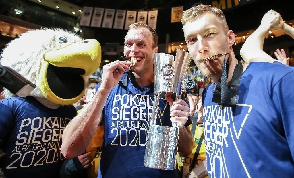 Und wir haben den Pokal: Maskottchen Albatros sowie Luke Sikma (Mitte) und Niels Giffey jubeln über den Sieg.