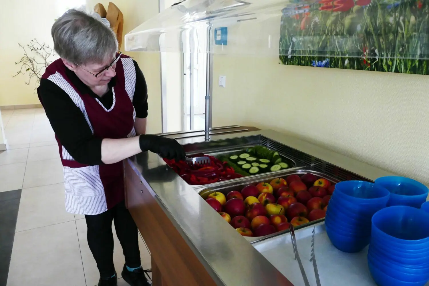 Servicekraft Andrea Lubrich füllt in der Grundschul-Mensa die Salatbar für die Kinder auf.
