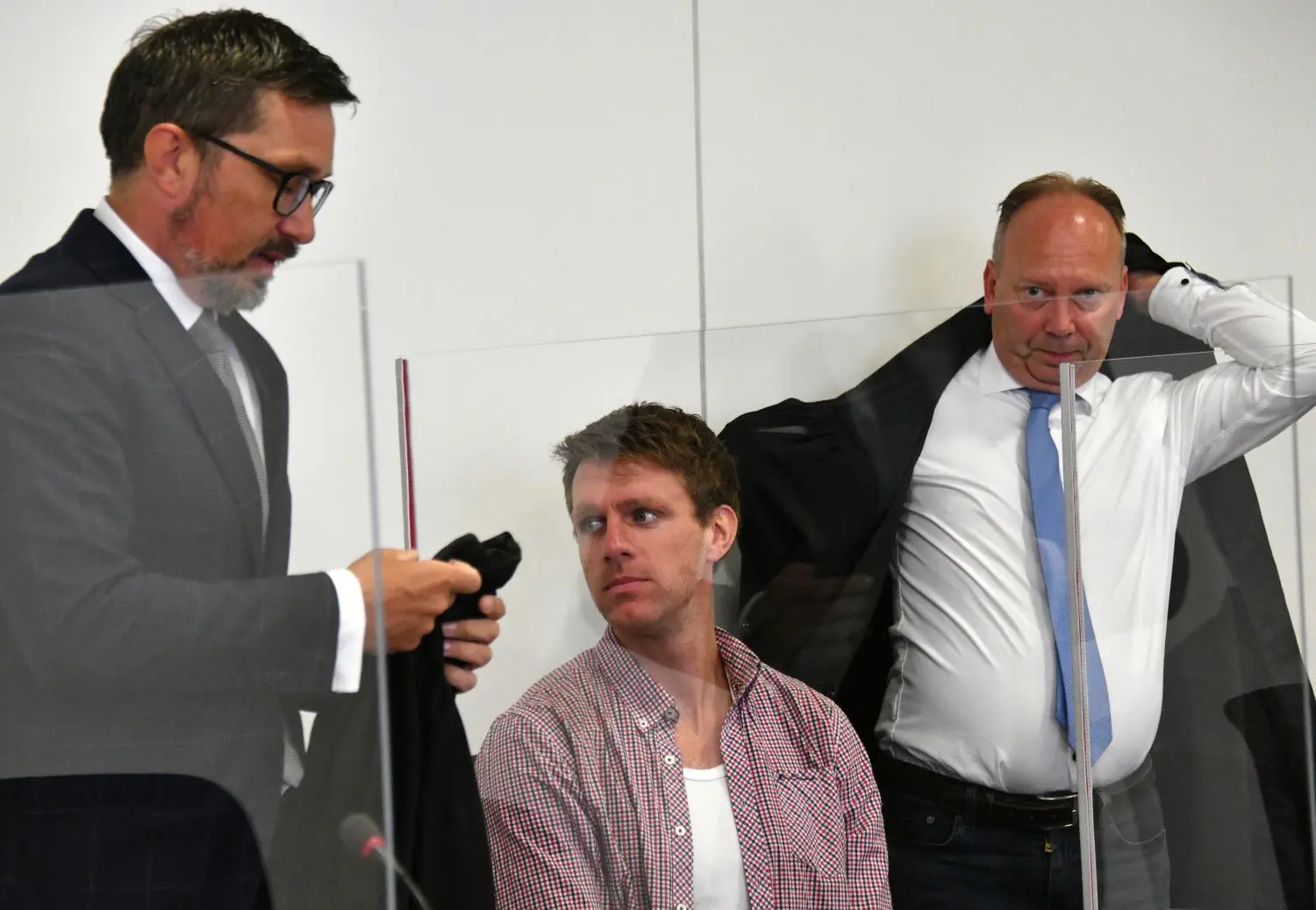 Der Ex-NPD-Politiker Maik Schneider wartet mit seinen Anwälten Mathias Noll (r) und Sven-Oliver Milke auf den Beginn der Hauptverhandlung. Schneider hatte im August 2015 mit Komplizen eine Sporthalle in Nauen (Havelland) in Brand gesteckt, weil dort Flüchtlinge untergebracht werden sollten.