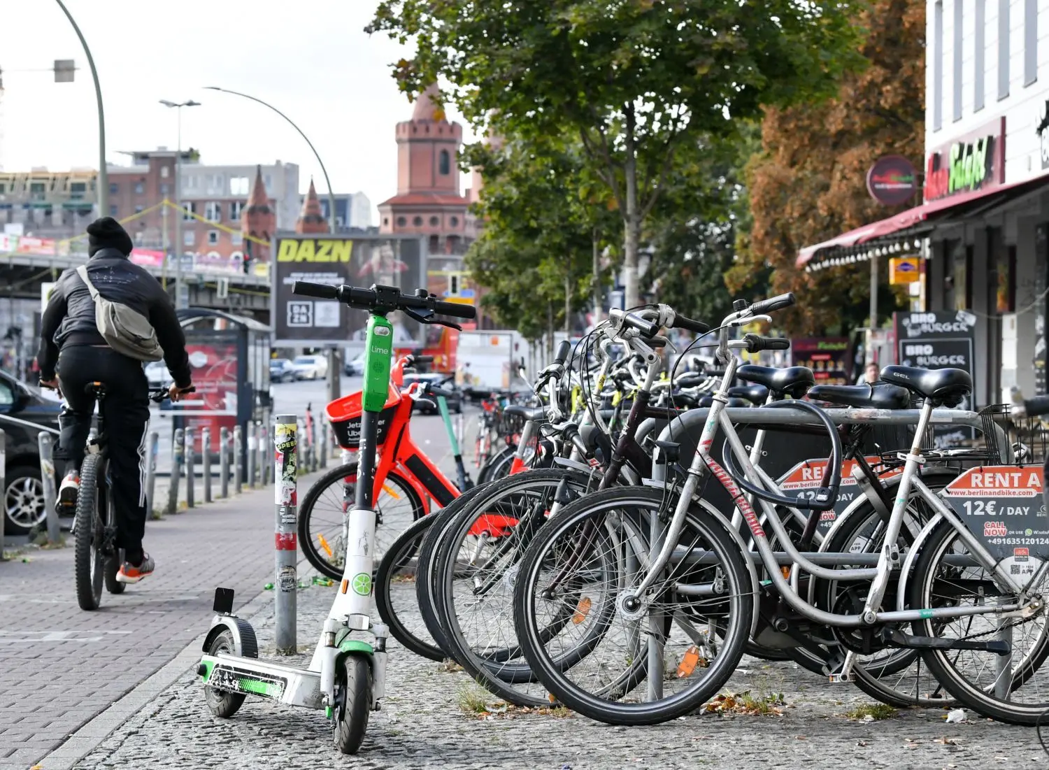 Zahlreiche Fahrräder, E-Fahrräder und E-Scooter stehen auf einem Gehweg an der Warschauer Straße an der Oberbaumbrücke. (Archivbild)