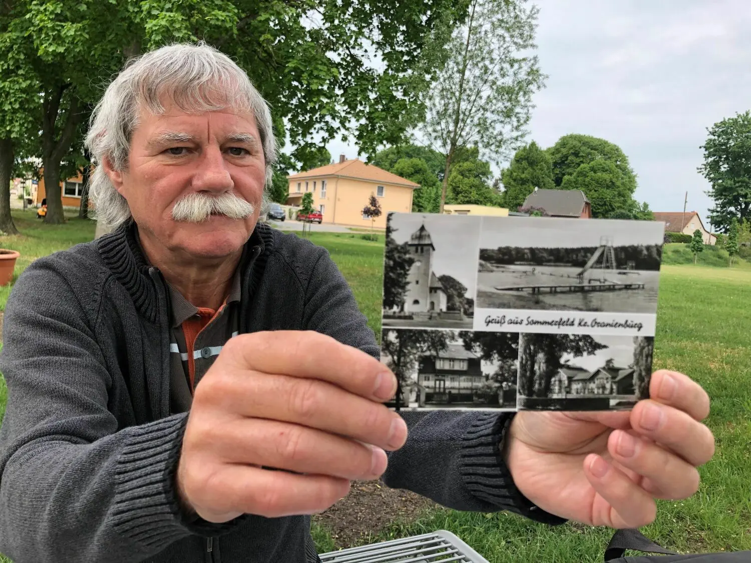 Der Beetzer Ortvorsteher Peter Winkler mit einer historischen Postkarte von Beetz, auf der auch die Badestelle zu sehen ist.