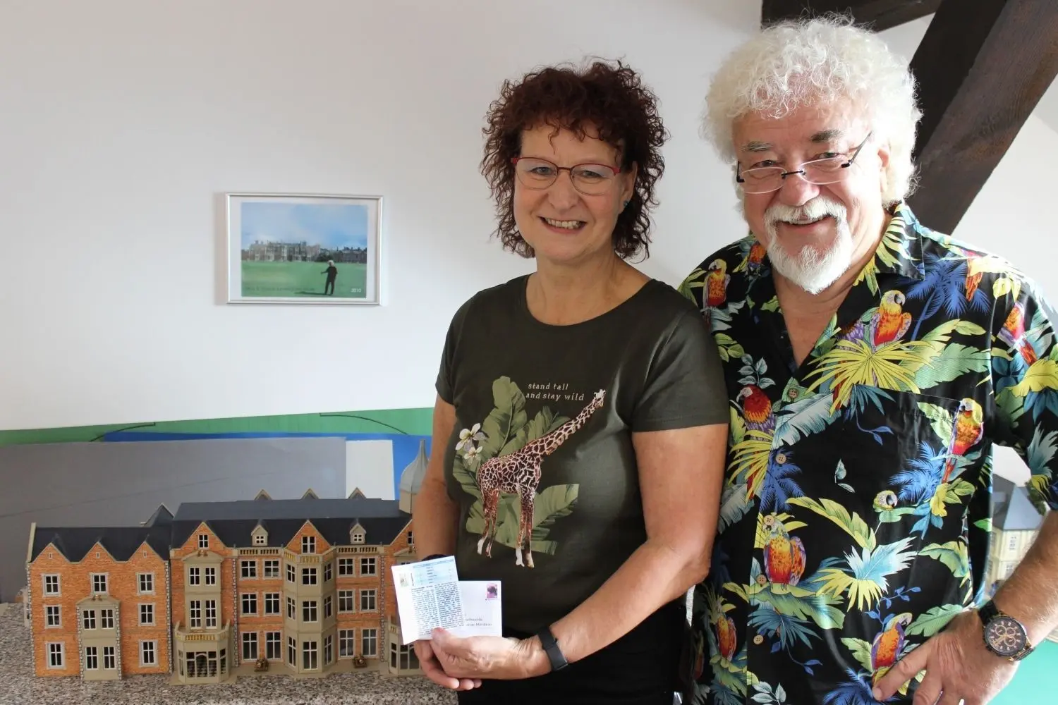 Marianne und Gerd Korup vor ihrem Sandringham House-Bauwerk. Marianne präsentiert das Yorktown Magazine.