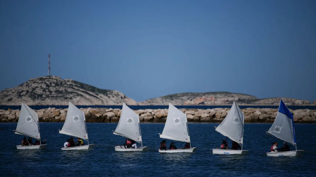 Vor Olympische Spiele 2024 Paris: 02.04.2024, Frankreich, Marseille: Schulkinder segeln während einer Vorführung im Jachthafen Roucas Blanc, der für die bevorstehenden Olympischen Sommerspiele in Marseille gebaut wurde. Marseille wird Gastgeber der olympischen Segelwettbewerbe während der Olympischen Spiele 2024 in Paris sein, die vom 26. Juli bis 11. August 2024 stattfinden. Foto: Daniel Cole/AP/dpa +++ dpa-Bildfunk +++