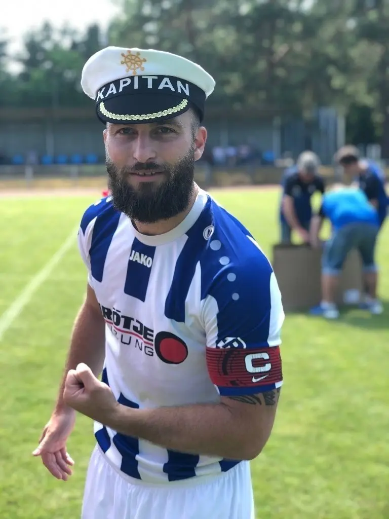 Briesens Christoph Hanke zeigt sich stolz als Kapitän mit Mütze.