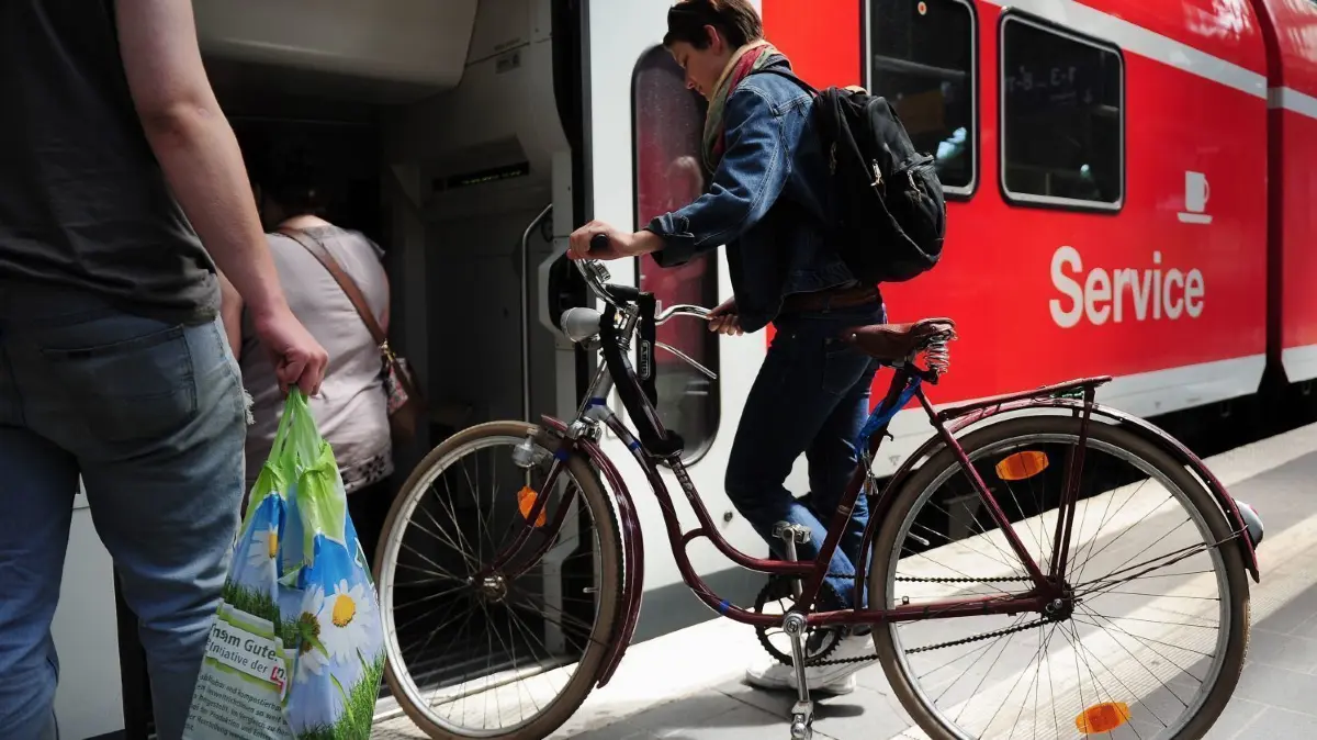Eine junge Frau besteigt einen Zug mit ihrem Fahrrad. Der VBB rechnet wegen des 9-Euro-Tickets mit einem großen Ansturm an Fahrgästen und bittet darum, ohne Fahrrad zu fahren.
ARCHIV - Eine junge Frau besteigt am 10.06.2011 auf dem Ostbahnhof in Berlin einen Zug mit ihrem Fahrrad. Mit Beginn der Sommerreisesaison wird es in den Fahrradabteilen der Bahnbetreiber enger. (zu "Mehr Fahrräder in Regionalzügen - Extra-Wagen auf zwei Linien" vom 21.05.2017) Foto: Hannibal Hanschke/dpa +++ dpa-Bildfunk +++