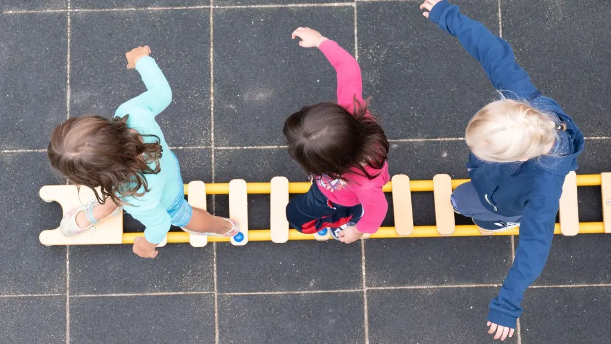 Symbolbild: Die Hortbetreuung in einer Neuruppiner Kita werden wegen Personalmangels ab Dienstag, 7. Dezember, vorläufig eingestellt.
Kinder balancieren während eines Pressetermins auf dem Spielplatz einer Kindertagesstätte auf einem Brett. (zu dpa «Kitaleitungskongress mit Studie von VBE zu Personalmangel - weitere Kita-Erhebung von Bertelsmann Stiftung») +++ dpa-Bildfunk +++