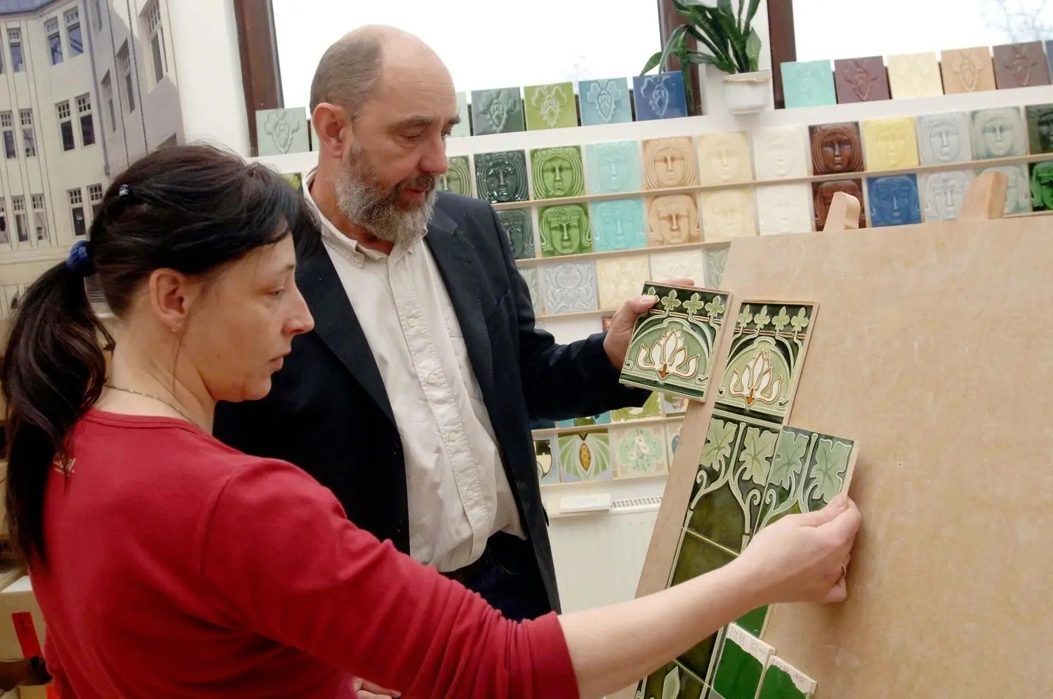 Hochspezialisiert:  Tomas Grzimek, Geschäftsführer der Golom GmbH Kunst- und Baukeramik in Sieversdorf, bespricht in Sieversdorf mit einer Keramikerin auf unserem Archivfoto von 2006 einen Mustervergleich bei einer Kollektion von Jugendstilfliesen, wie sie auch bis zum Brand in Altglietzen produziert wurden.