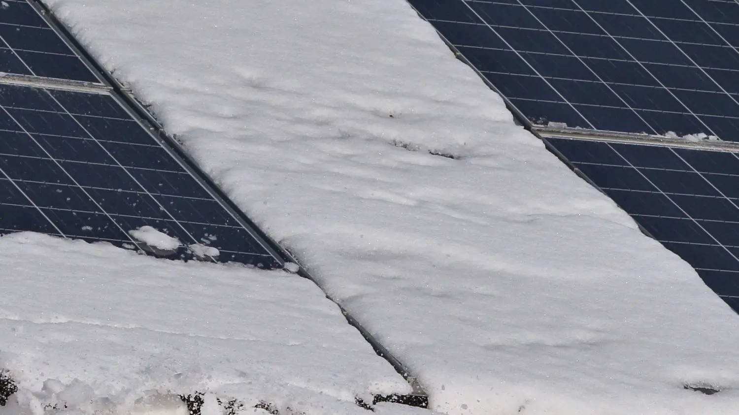 Schnee auf einem mit Solarzellen bedeckten Dach