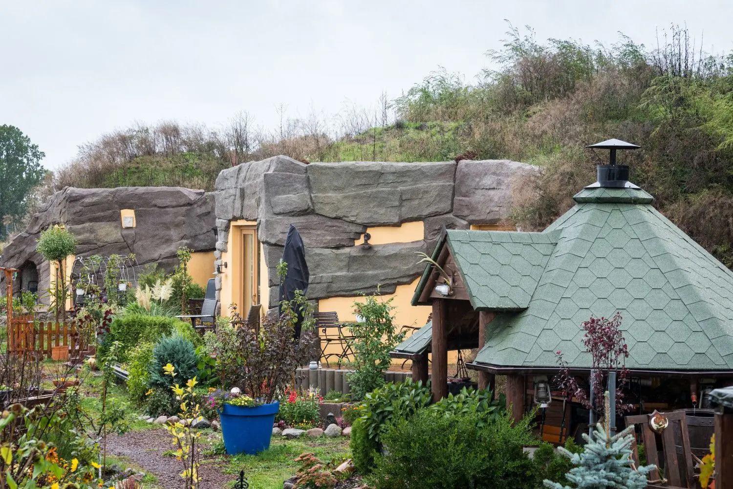 Die Appartments des Erdhügelhauses mit kleiner Terrasse stehen in dem großen Garten von Familie Radow. Die Gewölberäume aus Beton verbergen sich unter einer bis zu vier Meter dicken Erdschicht. Dadurch muss im Winter kaum geheizt werden, im Sommer bleibt es drinnen angenehm kühl.