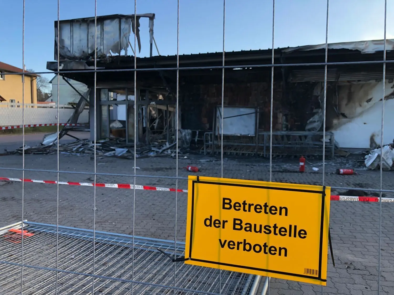 Die Brandruine in Bergfelde ist inzwischen eingezäunt. Das Gebäude, in dem eine Norma-Filiale, Getränke Hoffmann und eine Zweigstelle von Bäcker Steinecke untergebracht waren, ist nicht mehr zu retten und muss abgerissen werden.