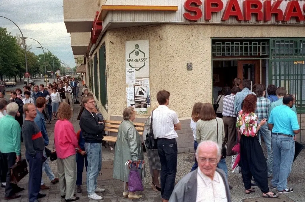 Der Tag an dem die D-Mark kam: Überall in der DDR bildeten sich am 1. Juli 1990 lange Schlangen wartender Menschen vor Sparkassen und Banken. Die DDR-Bürger tauschten ihre Guthaben in Westgeld ein.