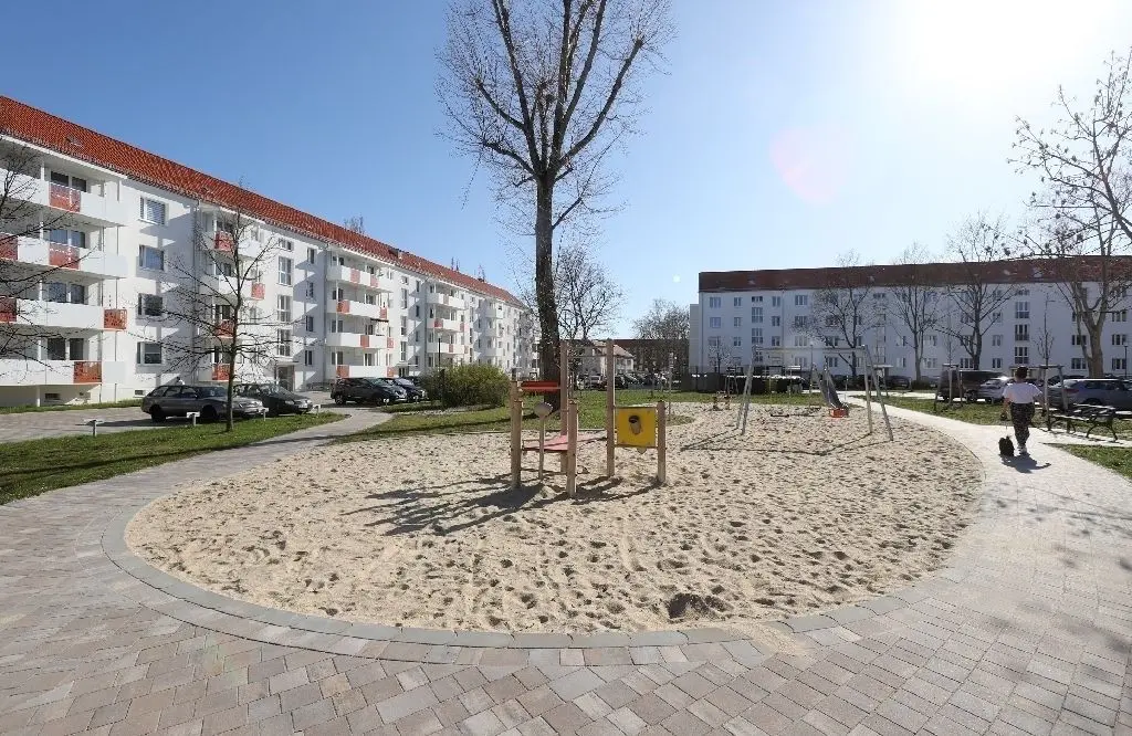 Luftig und sonnendurchflutet: Der Spielplatz mitten im Quartier ist großzügig angelegt. Ein breiter, gepflasterter Fußweg schlängelt sich durch das Wohngebiet.