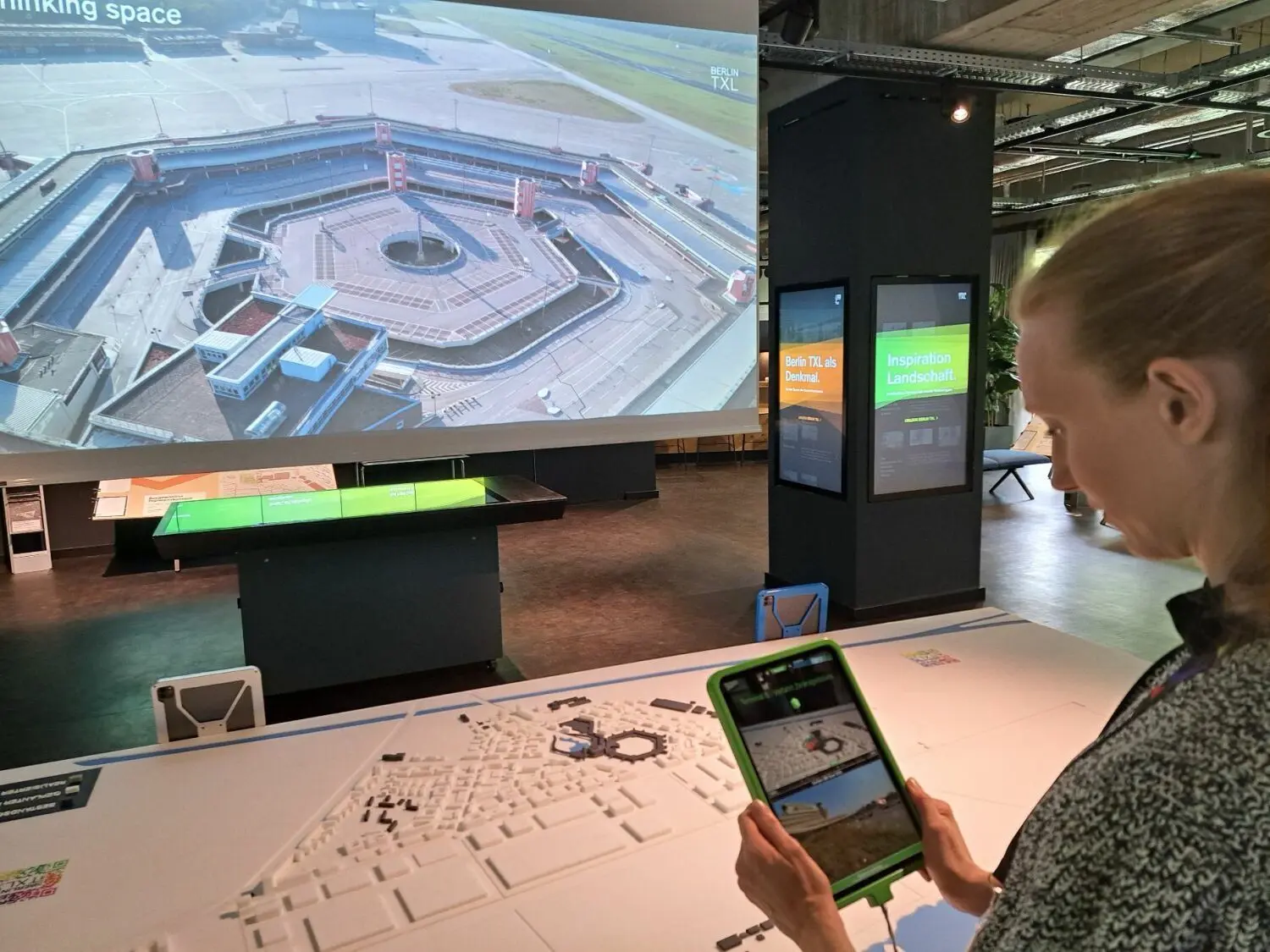 Mit Hilfe von Ausstellungs-Tablets kann man im neuen Infocenter TXL selbst Zeitreisen in Zukunft und Vergangenheit des ehemaligen Flughafengeländes Berlin-Tegel unternehmen.