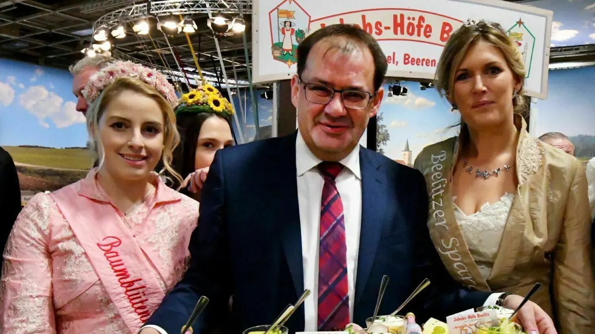 Werderaner Baumblütenkönigin 2017, Christin Schiffner (l) mit Brandenburgs Landwirtschaftsminister Jörg Vogelsänger (SPD) und der Beelitzer Spargelkönigin 2018, Nicole Hahn, am 18.01.2018 in Berlin in der Brandenburg Halle der Grünen Woche.
Brandenburgs Landwirtschaftsminister Jörg Vogelsänger (SPD) bietet am 18.01.2018 in Berlin in der Brandenburg Halle zusammen mit der Werderaner Baumblütenkönigin 2017, Christin Schiffner (l), und der Beelitzer Spargelkönigin 2018, Nicole Hahn, Spezialitäten zum Verkosten an. Foto: Bernd Settnik/dpa-Zentralbild/dpa ++ +++ dpa-Bildfunk +++