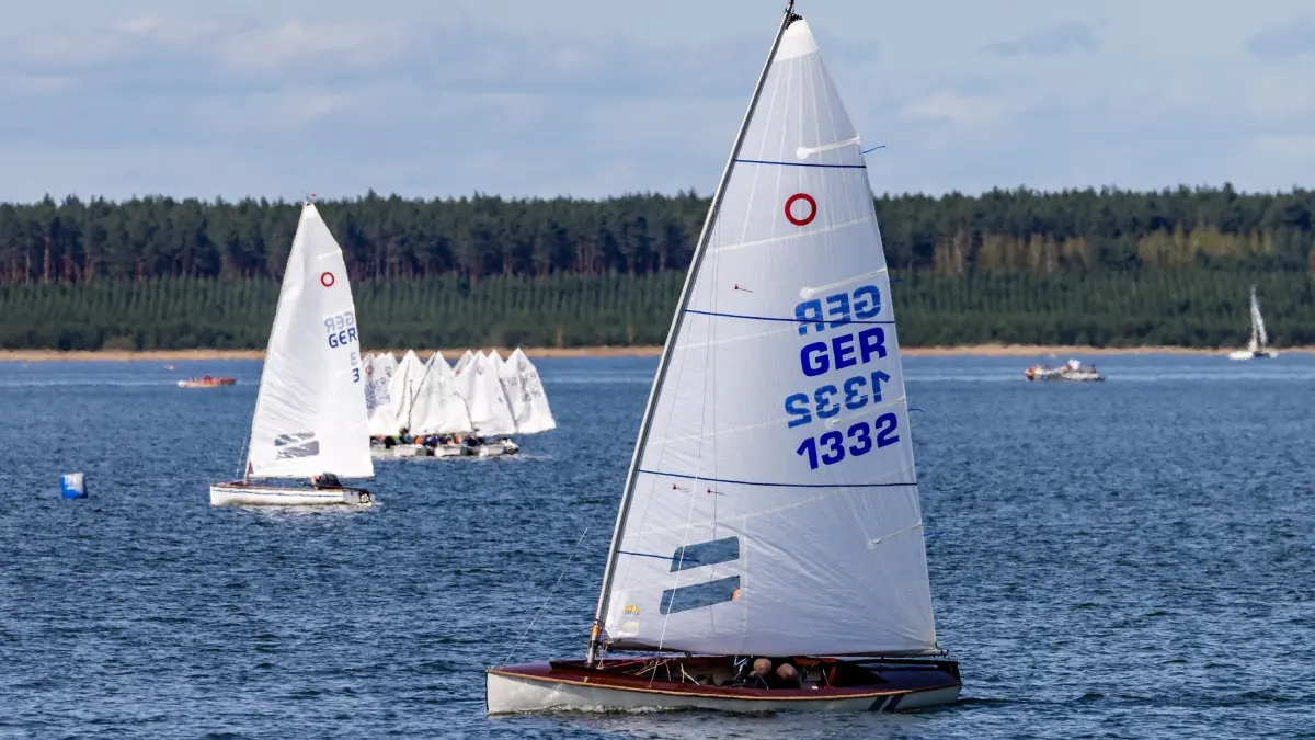 Sonniges Wetter im Lausitzer Seenland: 06.04.2024, Sachsen, Geierswalde: Segelboote fahren über den Geierswalder See an der Grenze zwischen den Bundesländern Brandenburg und Sachsen. (zu dpa: «Sommerwetter im April - Wetterdienst meldet rekordverdächtige Werte») Foto: Frank Hammerschmidt/dpa +++ dpa-Bildfunk +++
