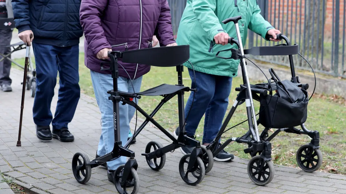 Tagespflege: ARCHIV - 20.03.2024, Brandenburg, Lenzen: In der "Tagespflege Am Brink" des DRK in Lenzen sind Senioren bei einem Spaziergang mit Rollatoren und Stöcken unterwegs. (zu dpa: «Drei Länder wollen neue Wege bei der Pflege gehen und Ärzte entlasten») Foto: Bernd Wüstneck/dpa +++ dpa-Bildfunk +++