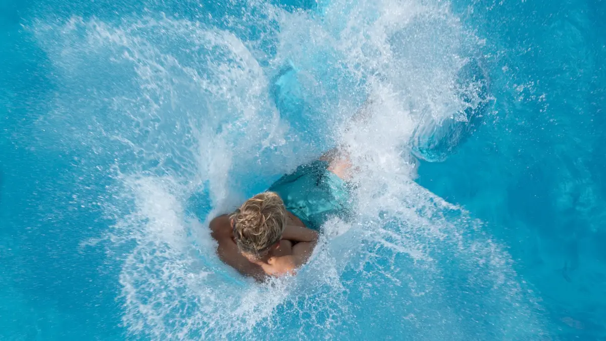 Sprung ins Schwimmbecken (Symbolbild): ARCHIV - 19.08.2023, Sachsen, Dresden: Ein Junge springt im Freibad vom 5-Meter-Turm ins Wasser. (zu dpa: «Freibad in Trier startet außergewöhnlich früh in die Saison») Foto: Sebastian Kahnert/dpa +++ dpa-Bildfunk +++