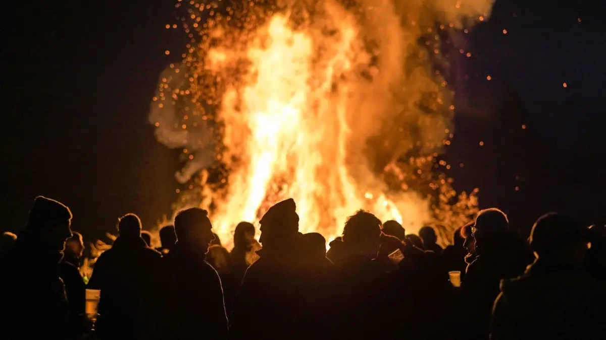 Brauchtumsfeuer an Ostern oder zum 1. Mai sind in der Region Tradition. Jetzt hat das brandenburgische Umweltministerium die Gebühren für Genehmigungen erhöht. Bedeutet die Änderung das Aus für solche Veranstaltungen? (Symbolbild)
Besucher schauen sich das Branitzer Osterfeuer an. Die Kameraden der Freiwilligen Feuerwehr des Cottbuser Ortsteiles Branitz hatten bei den Einwohnern und Gewerbetreibenden etwa 25 Kubikmeter Holzabfall gesammelt und am Vormittag des heutigen Karsamstag zu einem Holzhaufen geschichtet. Zu dem Osterfeuer kamen mehrere Hundert Besucher. +++ dpa-Bildfunk +++