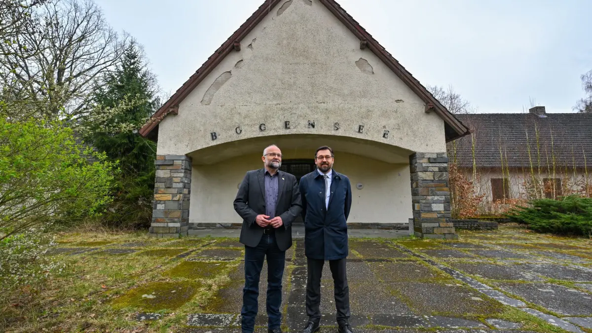 Areal am Bogensee mit ehemaliger NS–Villa: ARCHIV - 22.03.2024, Brandenburg, Wandlitz: Daniel Kurth (l, SPD), Landrat vom Landkreis Barnim, und Oliver Borchert (Freie Bürgergemeinschaft Wandlitz), Bürgermeister von Wandlitz, stehen vor der Villa von NS-Propagandaminister Goebbels auf dem Areal am Bogensee. Beide Politiker hatten am selben Tag ein Abrissmoratorium zum Erhalt das Areals Bogensee unterzeichnet. Das nördlich von Berlin gelegene Areal am Bogensee umfasst mit der ehemaligen FDJ-Hochschule Wilhelm Pieck und der Villa von Reichpropaganda-Minister Joseph Goebbels. Die zuletzt wieder sehr intensiv geführte Diskussion zu einem Nachnutzungskonzept Bogensee ist bislang noch ohne Ergebnis und findet nach wie vor wenig Unterstützung durch die Berliner Landesregierung als Eigentümerin des Areals. (zu dpa: «Debatte um Areal mit Goebbels Villa - Bürgermeister kritisiert Senator») Foto: Patrick Pleul/dpa +++ dpa-Bildfunk +++