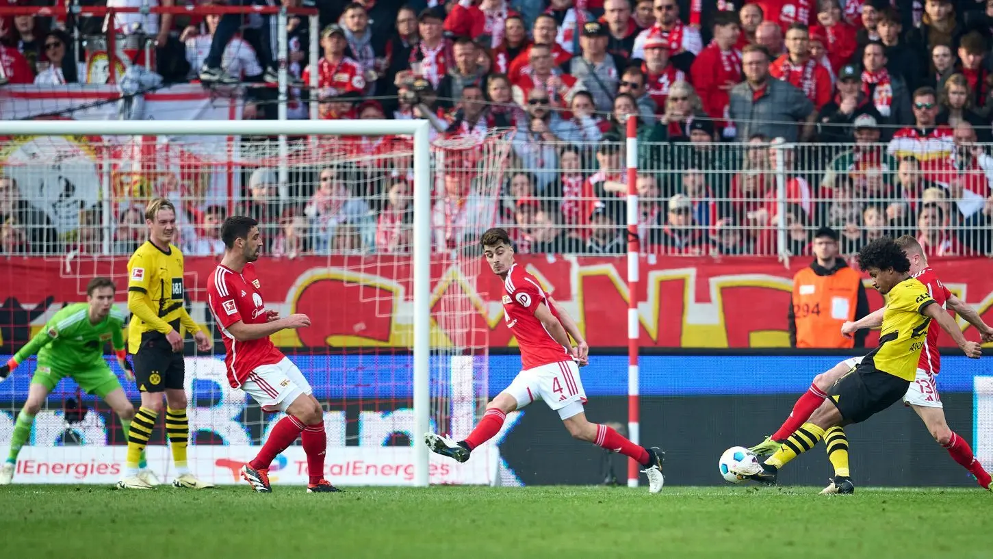 Gegen den Kunstschuss von Dortmunds Karim Adeyemi (rechts) ist Frederik Rönnow im Tor von Union Berlin machtlos.
