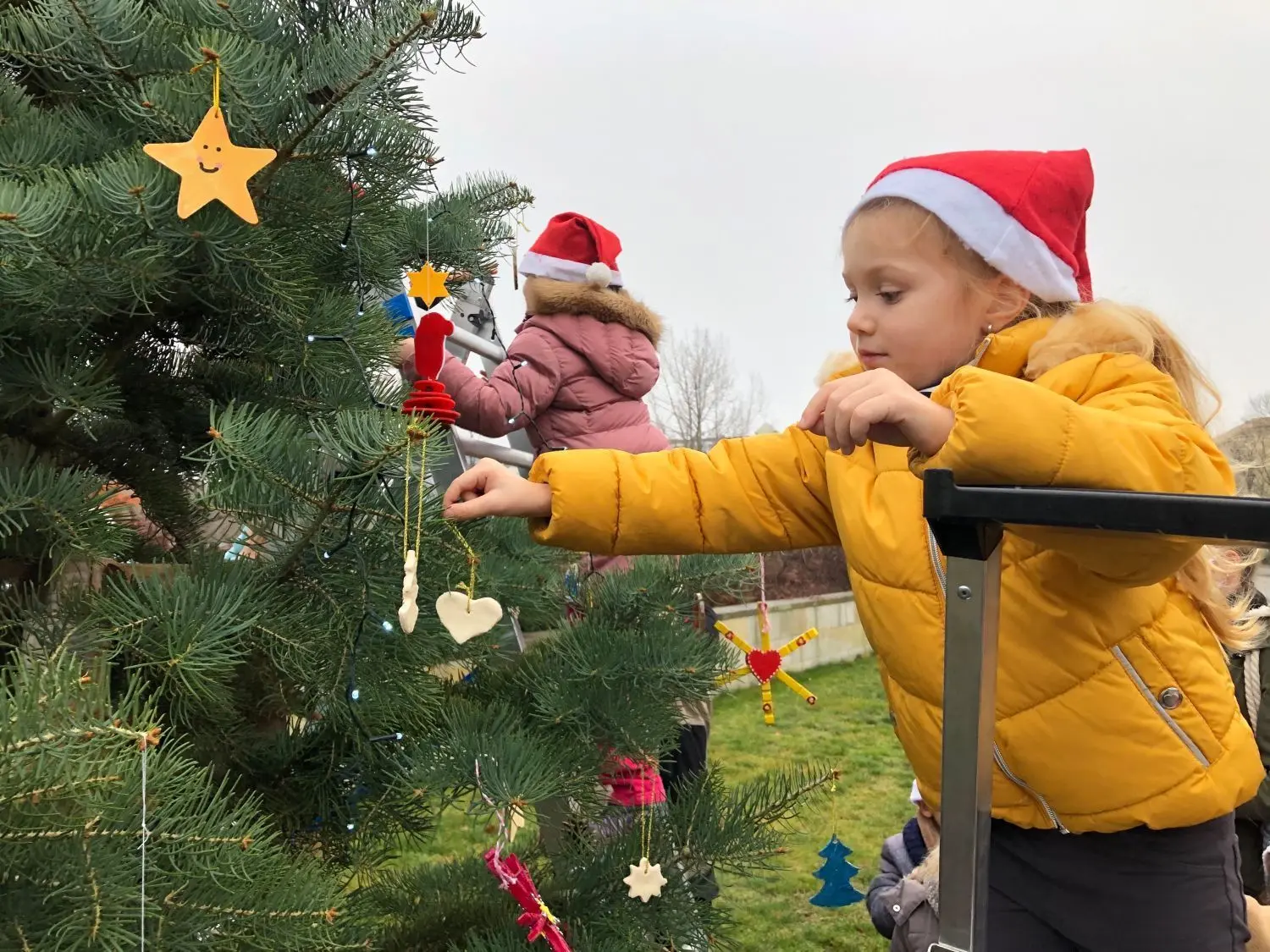 Kinder der ASB-Kita „Haus der fröhlichen Kinder“  schmücken den Weihnachtsbaum der Eisenhüttenstädter Wohnungsbaugenossenschaft.