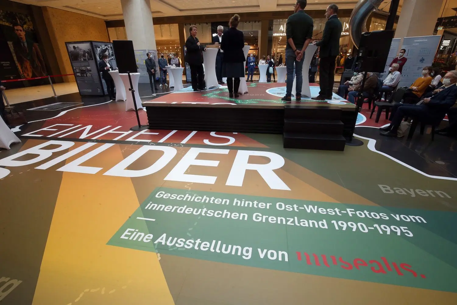 Menschen nehmen an der Eröffnung der Ausstellungen „Umbruch Ost“ und „Einheitsbilder“ der Bundesstiftung zur Aufarbeitung der SED Diktatur in der Mall of Berlin teil.