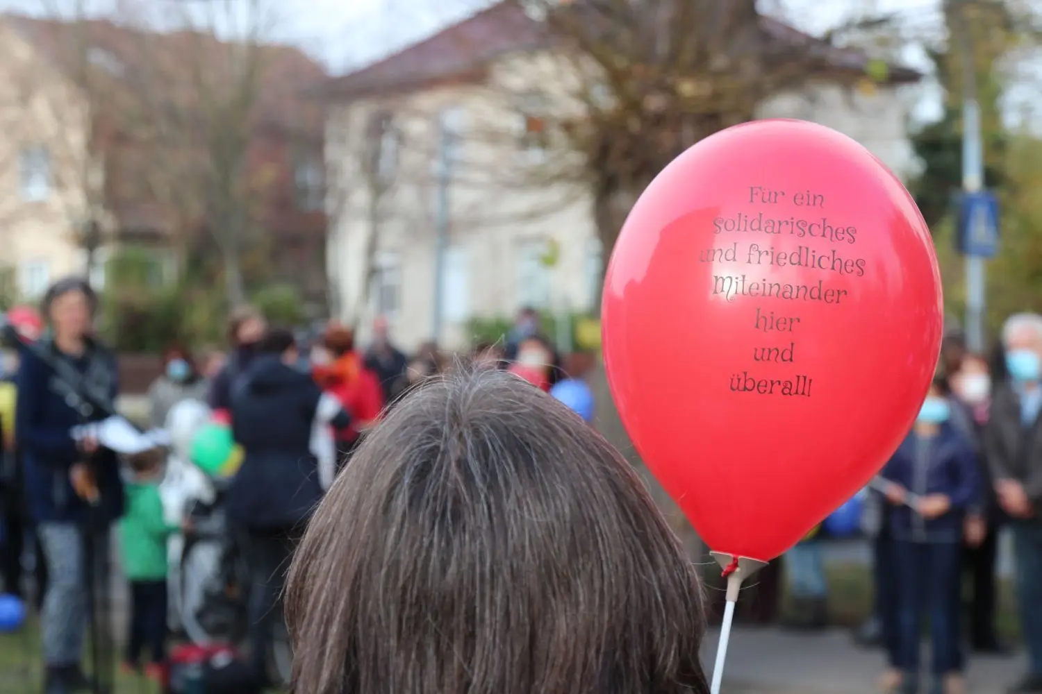 Botschaft auf dem Luftballon: „Für ein solidarisches und friedliches Miteinander hier und überall“.