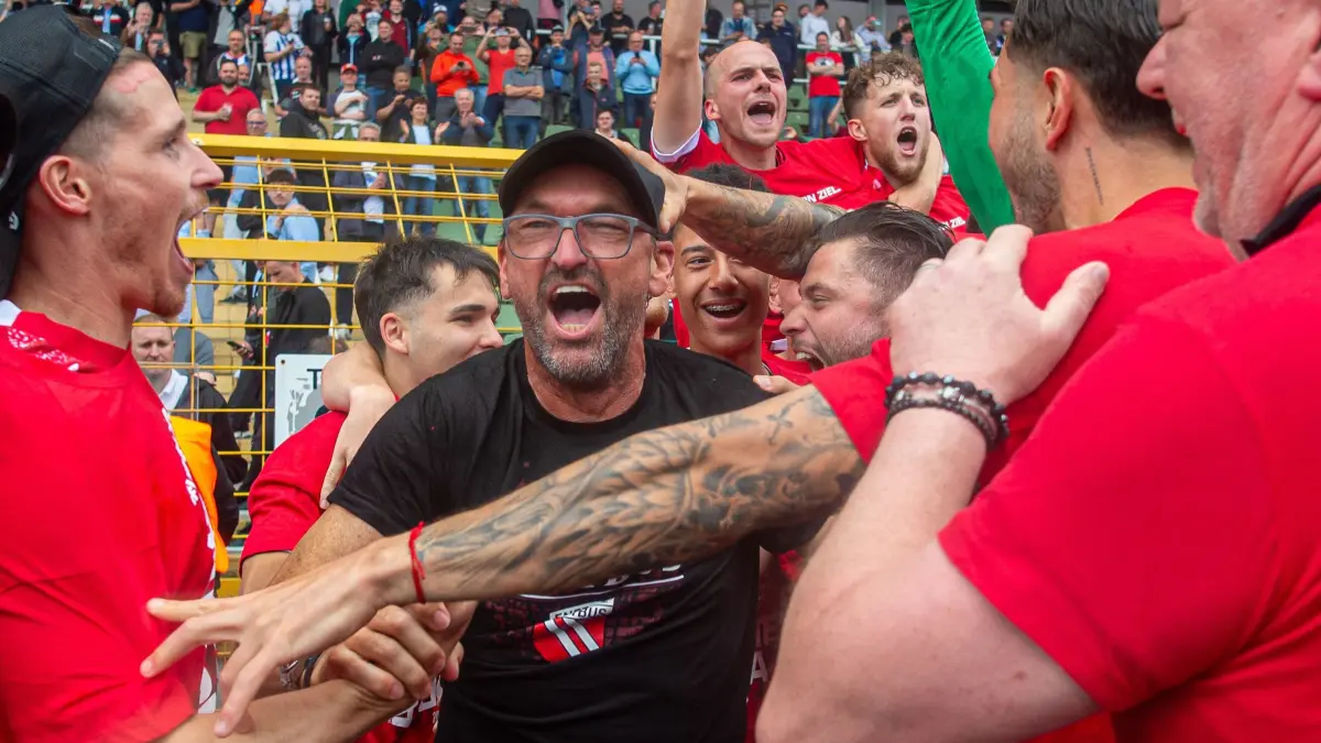 RLNO Hertha BSC II — Energie Cottbus 2023/24: Fussball, Herren, Saison 2023/24, Regionalliga Nordost (34. Spieltag), Hertha BSC II - FC Energie Cottbus, Cottbus feiert den Aufstieg in die 3. Liga, v.l. Axel Borgmann (Energie Cottbus), Trainer Claus-Dieter Pele Wollitz (Energie Cottbus), Phil Halbauer (Energie Cottbus), Tim Campulka (Energie Cottbus), 19.05. 2024, Foto: Sebastian Räppold / Matthias Koch