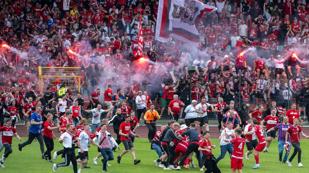 RLNO Hertha BSC II — Energie Cottbus 2023/24: Fussball, Herren, Saison 2023/24, Regionalliga Nordost (34. Spieltag), Hertha BSC II - FC Energie Cottbus, Cottbus feiert den Aufstieg in die 3. Liga, Fans stürmen nach Abpfiff den Rasen, unten rechts Tim Campulka (4, Energie Cottbus) 19.05. 2024, Foto: Matthias Koch