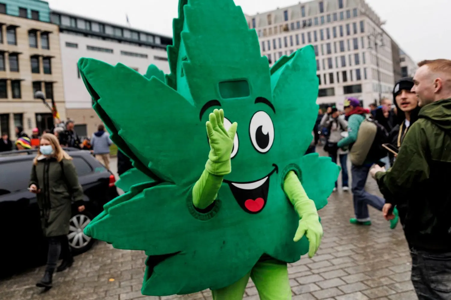 Ein Teilnehmer, der ein Kostüm in Form eines Hanfblattes trägt, winkt während der Demonstration für die Legalisierung von Cannabis.