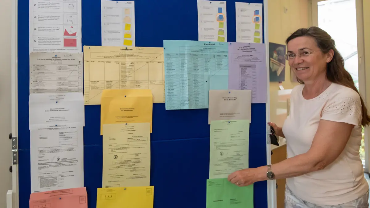 Heike Voigt, Leieterin der Wahlbehörde Schwedt, zeigt die Infotafel mit den Briefwahlunterlagen, die vor der Meldebehörde im Schwedter Rathaus steht.