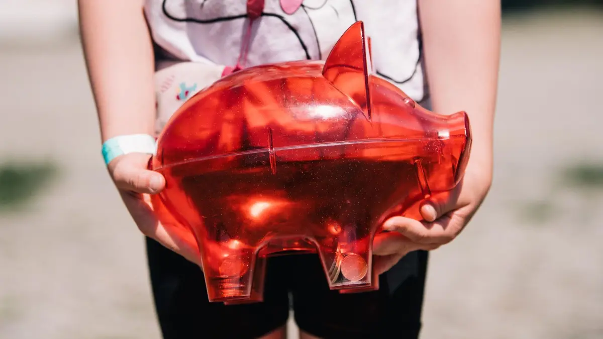 Kind mit Sparschwein: ARCHIV - Bargeld ist gut, ein Konto aber auch? Für Kinder und Jugendliche gibt es besondere Girokonten mit Schutz vor Verschuldung. (zu dpa: «Wie Sie Ihrem Kind den Umgang mit Geld beibringen») Foto: Zacharie Scheurer/dpa-mag - Honorarfrei nur für Bezieher des Dienstes dpa-Magazin +++ dpa-Magazin +++