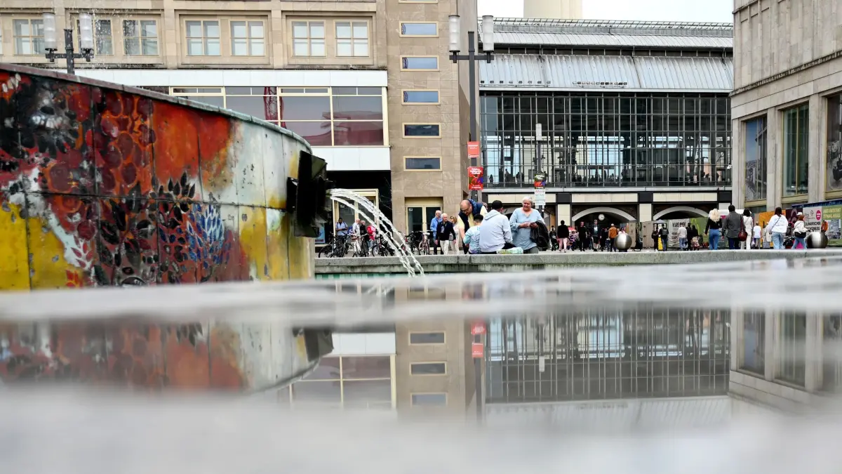 Regen in Berlin — Wetter: 30.05.2024, Berlin: In einer Pfütze spiegeln die umliegenden Gebäude und Passanten am Berliner Alexanderplatz. Gewitter, Regen und Hagel sorgen am Donnerstag für teils ungemütliches Wetter in Berlin und Brandenburg. Schon am Vormittag gibt es im Westen und in der Bundeshauptstadt Schauer, teilte der Deutsche Wetterdienst (DWD) mit. Ab Mittag ziehen örtlich schwere Gewitter auf, die sich bis zum Abend halten. Lokal eng begrenzt soll es Hagel, schwere Sturmböen und Starkregen zwischen 20 und 40 Litern pro Quadratmeter geben. Vereinzelt sind auch bis zu 60 Liter pro Quadratmeter möglich, wenn der Regen über Stunden anhält oder mehrere Gewitter an einem Ort zusammenkommen. Foto: Alina Schmidt/dpa +++ dpa-Bildfunk +++