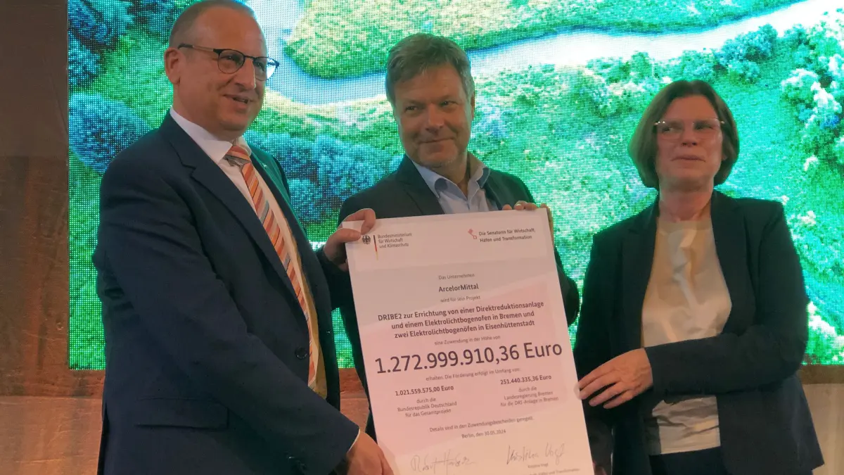 Thomas Bünger, CEO von ArcelorMittal Eisenhüttenstadt und Bremen, Bundeswirtschaftsminister Robert Habeck und Bremens Wirtschaftssenatorin Kristina Vogt mit dem Förderbescheid für die Flachstahlstandorte von ArcelorMittal in Eisenhüttenstadt und Bremen.