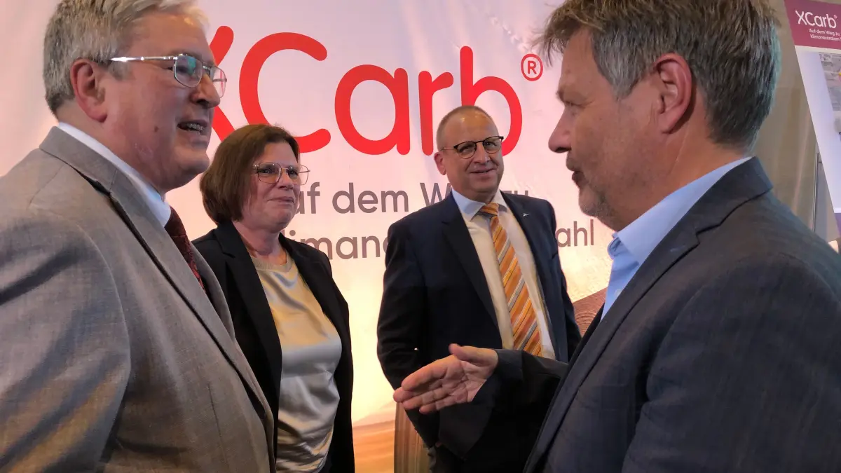 Brandenburgs Wirtschaftsminister Jörg Steinbach (l.) im Gespräch mit Bundeswirtschaftsminister Robert Habeck bei der Übergabe des nationalen Förderbescheids in Eisenhüttenstadt. Im Hintergrund sind Bremens Wirtschaftssenatorin Kristina Vogt und Thomas Bünger, CEO von ArcelorMittal Eisenhüttenstadt und Bremen zu sehen.