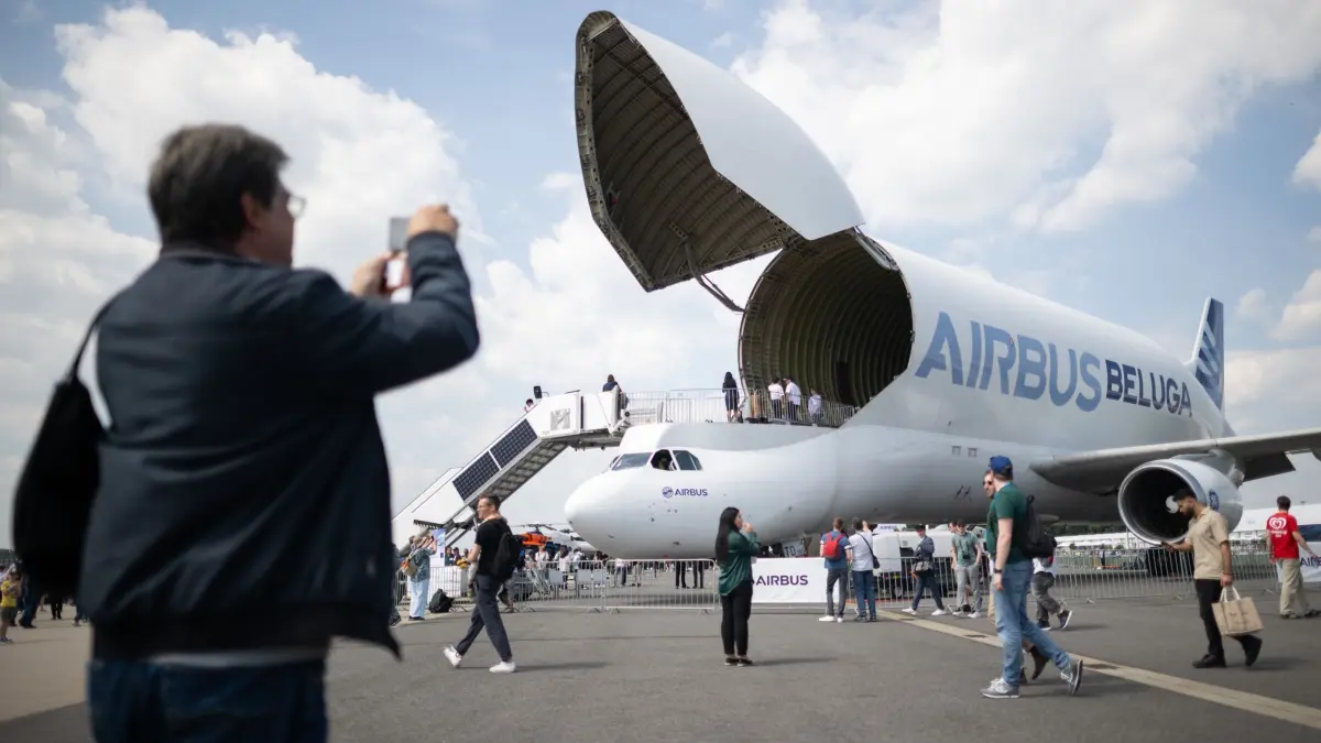 Internationale Luft– und Raumfahrtausstellung 2024: 08.06.2024, Brandenburg, Schönefeld: Eine Frau fotografiert während des Publikumstags der Internationalen Luft- und Raumfahrtausstellung (ILA) auf dem Gelände vom Flughafen Berlin Brandenburg (BER) einen A300-600ST Super Transporter, auf «Beluga» genannt. Die Messe findet vom 5. bis 9. Juni 2024 unter dem Motto «Pioneering Aerospace» statt. Foto: Sebastian Christoph Gollnow/dpa +++ dpa-Bildfunk +++