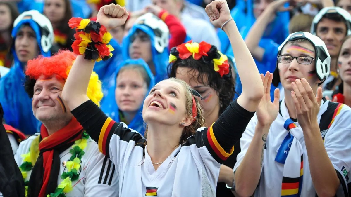 World Cup 2014 — Fanmeile Berlin: ARCHIV - 25.06.2014, Berlin: Besucher jubeln am 26.06.2014 beim «Public Viewing» des WM-Fußballspiel Deutschland - USA am Brandenburger in Berlin. Foto\ Ole Spata/dpa +++(c) dpa - Bildfunk+++ (zu dpa: «Wetter zum EM-Start: Überwiegend trocken und milde Temperaturen in NRW») Foto: Ole Spata/dpa +++ dpa-Bildfunk +++