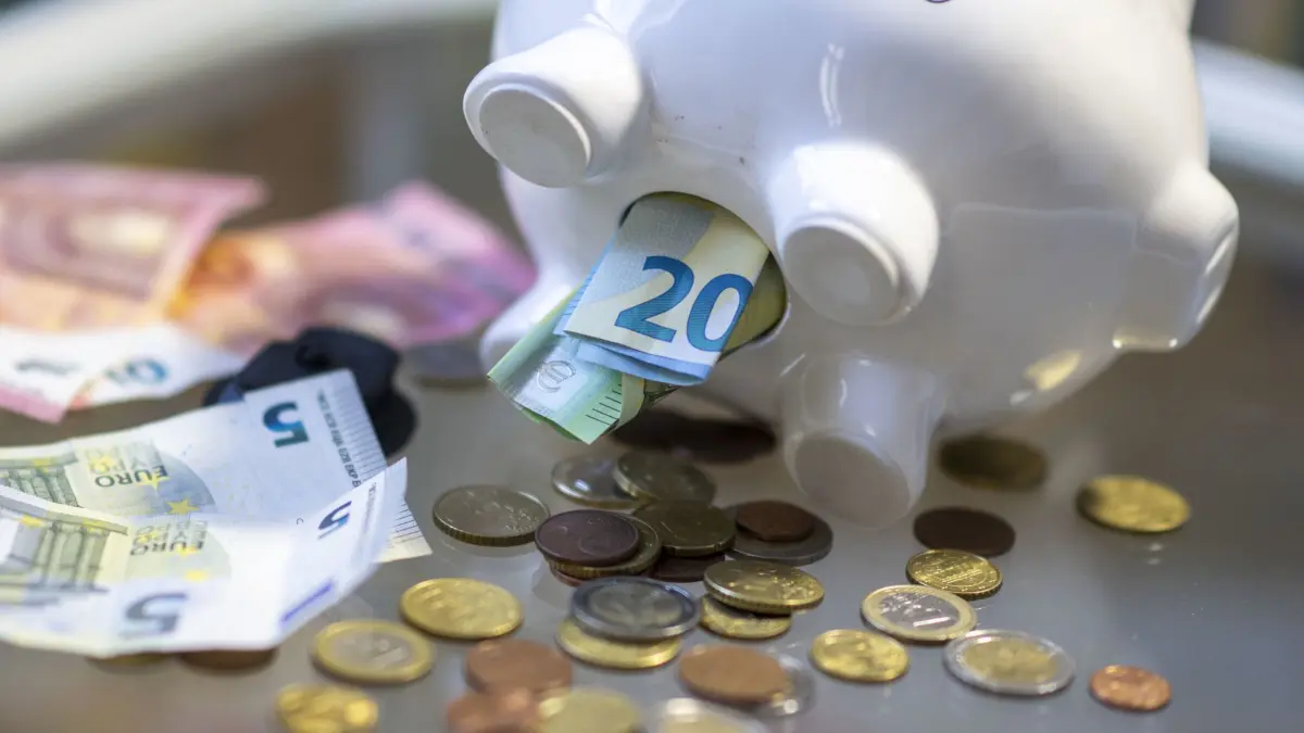 ILLUSTRATION - 23.10.2023, Sachsen, Leipzig: Geld steckt im Bauch eines Sparschweins. (zu dpa: «Viele Menschen können keine Rücklagen bilden») Foto: Hendrik Schmidt/dpa +++ dpa-Bildfunk +++