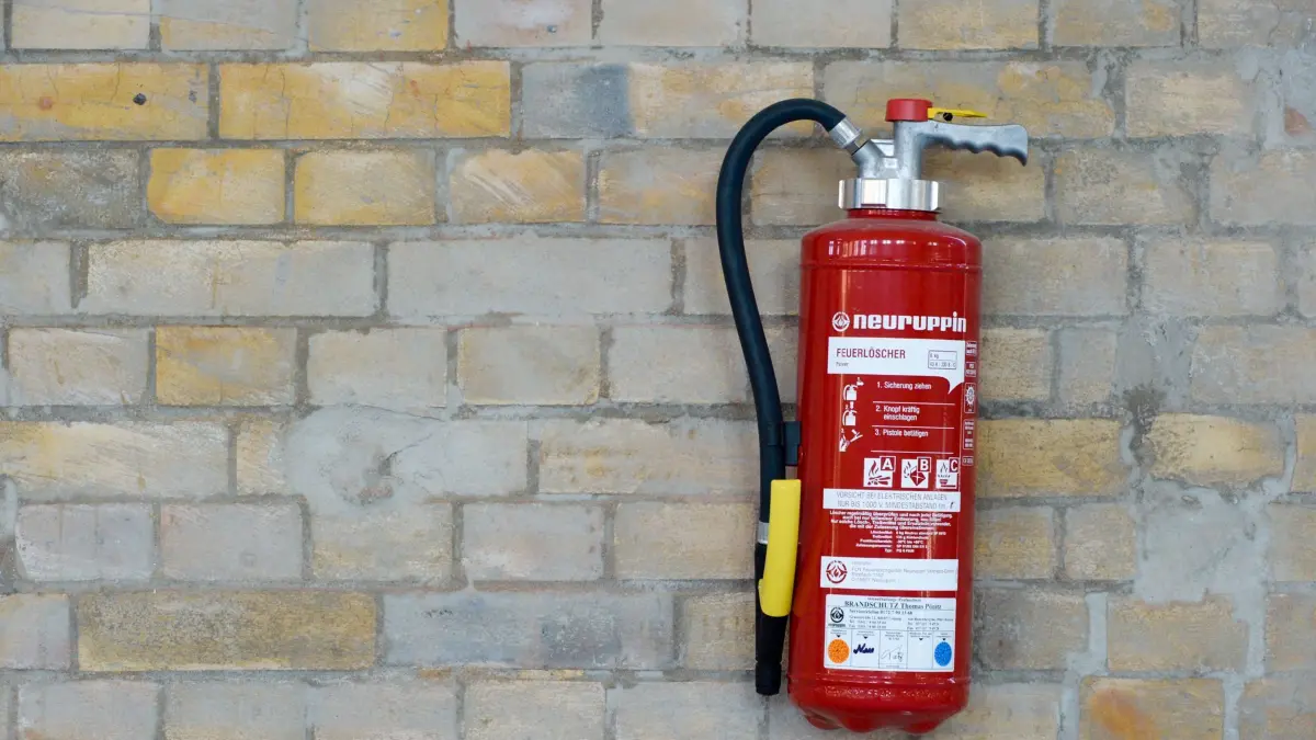 ARCHIV - 29.09.2014, Sachsen-Anhalt, Lutherstadt Wittenberg: Ein Feuerlöscher (Pulver) hängt an einer Wand. In manchen Thüringer Schulen lernen die Jüngsten heute schon, wie Brandschutz funktioniert. Pläne, im ganzen Land für eine solche Ausbildung zu sorgen, provozieren bei manchen Kommunalvertretern allerdings Ablehnung und Kritik. Es geht ums Geld. (zu dpa «Landkreistag wehrt sich gegen flächendeckende Brandschutzerziehung» vom 15.03.2018) Foto: Peter Endig/dpa-Zentralbild/dpa +++ dpa-Bildfunk +++