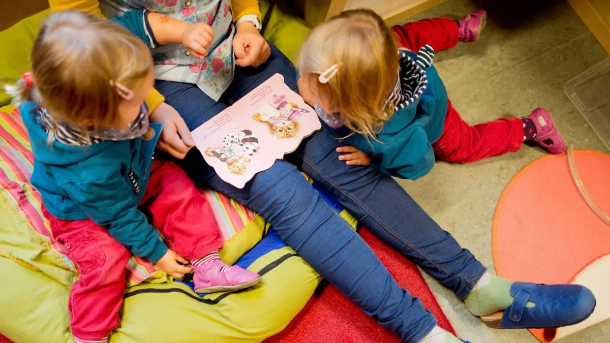ARCHIV - Eine Erzieherin liest am 16.10.2013 mit Zwillingen ein Buch in einer Kindertagesstätte der Arbeiterwohlfahrt (AWO) in Hannover (Niedersachsen). Die Kommunen in Niedersachsen rechnen nach dem Kita-Urteil von Karlsruhe nicht mit einer Klagewelle. Foto: Julian Stratenschulte/dpa (zu dpa «Kommunen rechnen nach Kita-Platz-Urteil nicht mit Klagewelle» vom 22.10.2016) +++ dpa-Bildfunk +++