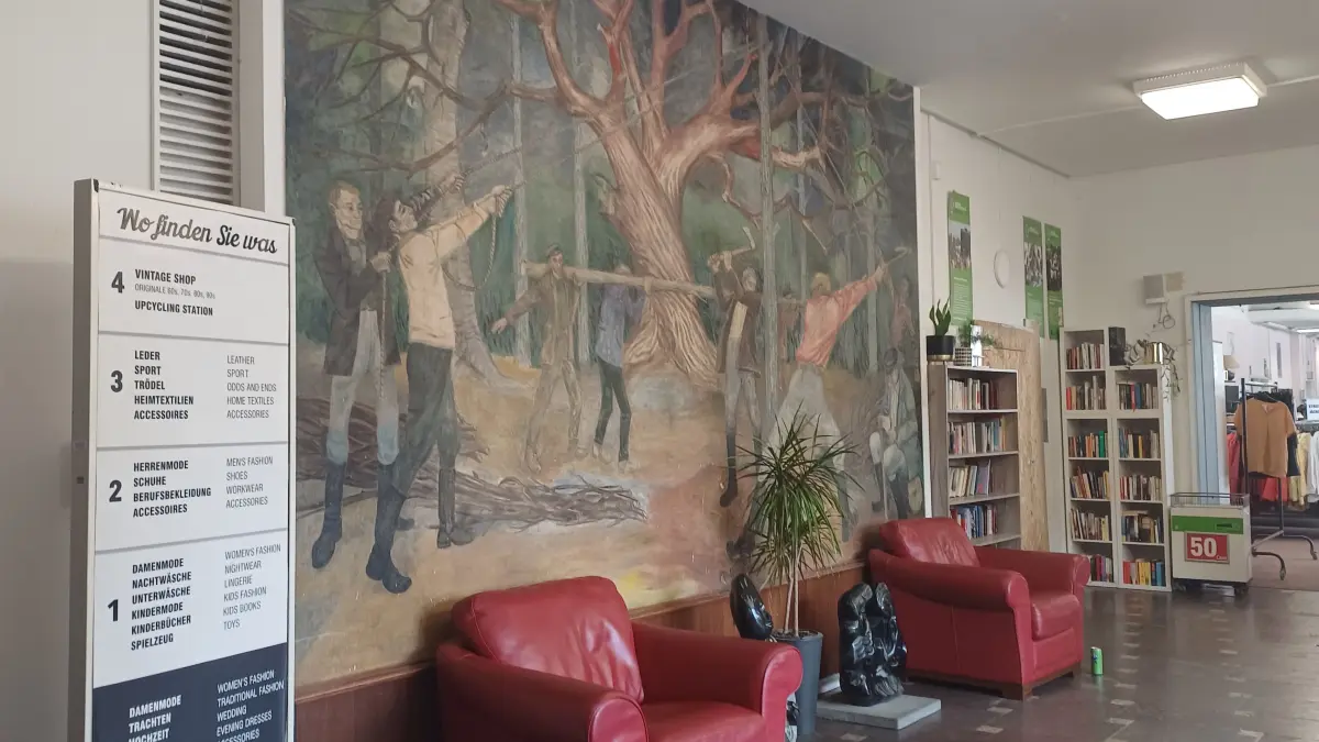 Im Erdgeschoss des Humana-Kaufhauses am Frankfurter Tor in Berlin hängt das Wandbild “Holzfäller” des Maler Gabriele Mucchi von 1958.