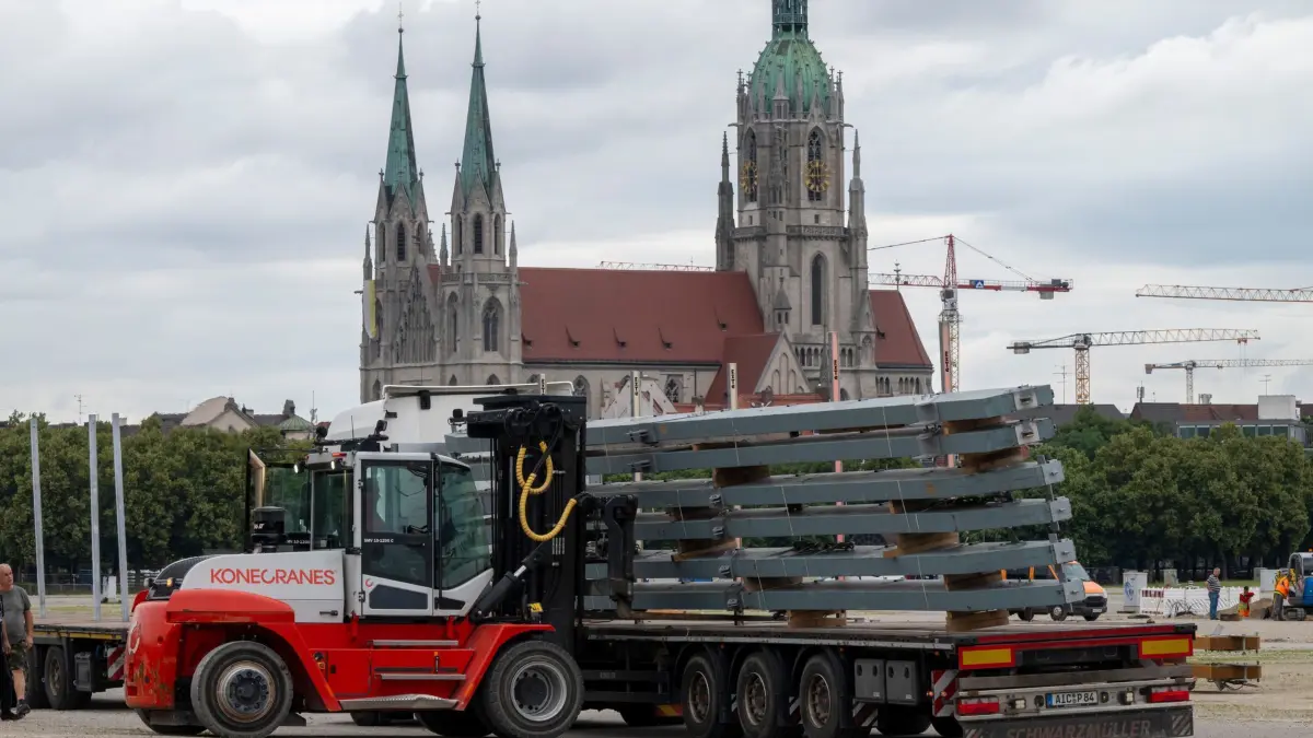 Aufbau Oktoberfest: 01.07.2024, Bayern, München: Diverse Bauteile für die großen Bierzelte werden zum Aufbaustart für das Oktoberfest auf der Theresienwiese angeliefert. Im Hintergrund steht die St. Paul-Kirche. Das 189. Oktoberfest findet vom 21. September bis 6. Oktober 2024 auf der Münchner Theresienwiese statt. Foto: Peter Kneffel/dpa +++ dpa-Bildfunk +++
