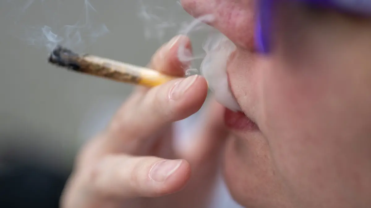 Eine Frau raucht einen Joint: ARCHIV - Vor der Arbeit gekifft? Ein Arbeitgeber darf Beschäftigte nicht einfach zum Drogencheck zwingen. (zu dpa: «Cannabis-Konsum: Kann der Arbeitgeber Drogenchecks anordnen?») Foto: Monika Skolimowska/dpa/dpa-mag - Honorarfrei nur für Bezieher des Dienstes dpa-Magazin +++ dpa-Magazin +++