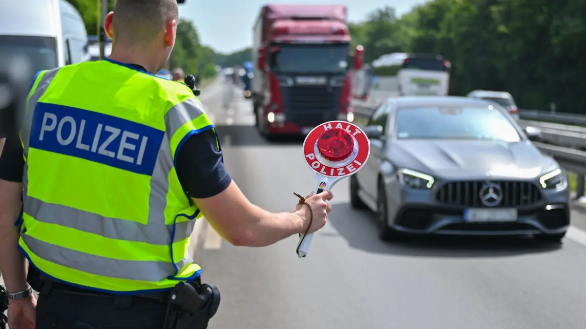 Euro 2024: Bundespolizei kontrolliert zur Fußball-EM: ARCHIV - 21.06.2024, Brandenburg, Frankfurt (Oder): Ein Beamter der Bundespolizei steht auf der Autobahn A12 nahe dem deutsch-polnischen Grenzübergang und stoppt ein Auto mit polnischen Fußballfans, die unterwegs nach Berlin zum EM-Spiel Polen gegen Österreich sind. (zu dpa: «Grenzkontrollen wegen der EM: 275 Schleuser festgenommen») Foto: Patrick Pleul/dpa +++ dpa-Bildfunk +++